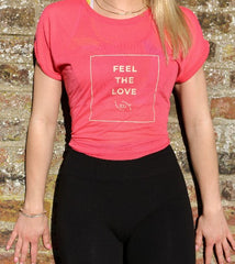 Model Close up front shot model in Feel the Love logo T. Lightweight, coral colour, hip length, cap sleeves 