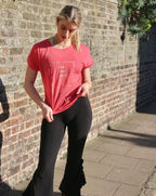Model is wearing the Feel the Love logo T. Lightweight, coral colour, hip length, cap sleeves 